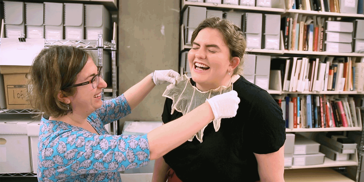 A staff members places an archival collar on a student