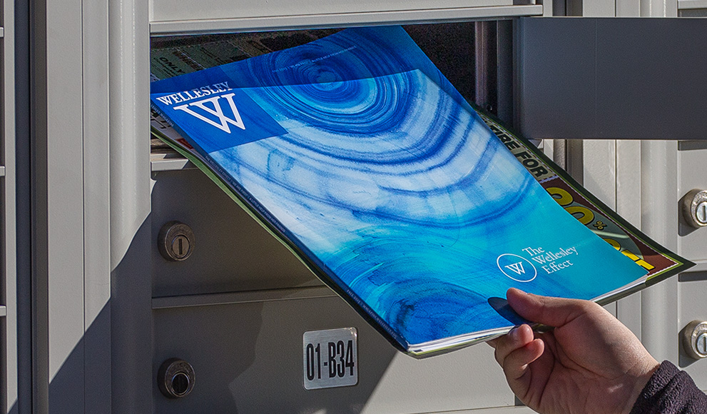 A hand pulls the Fall 2015 Wellesley magazine from a mailbox. 