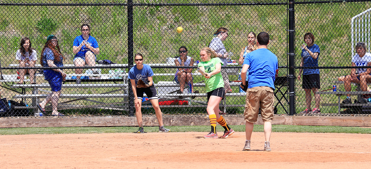 Math vs. Physics in the Battle of the Bats Fans look on from the stands as a softball player hits the ball