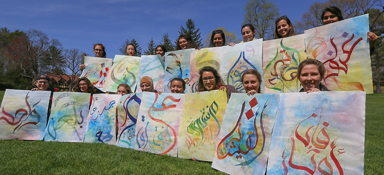 Spotlight on Teaching: MES/ART116: Arabic Calligraphy Students hold art from a calligraphy project exploring Arabic letters