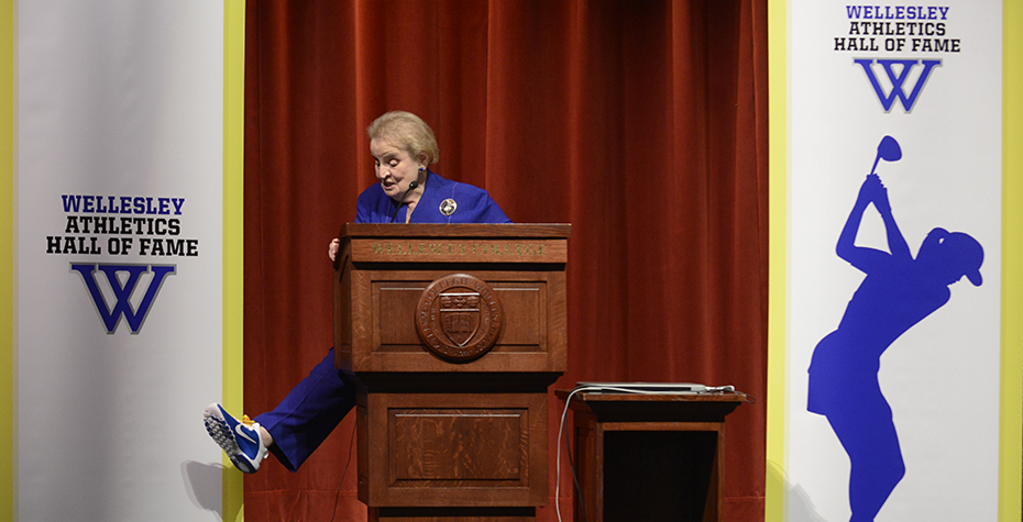 Madeleine Albright shows off blue sneaker from behind podium