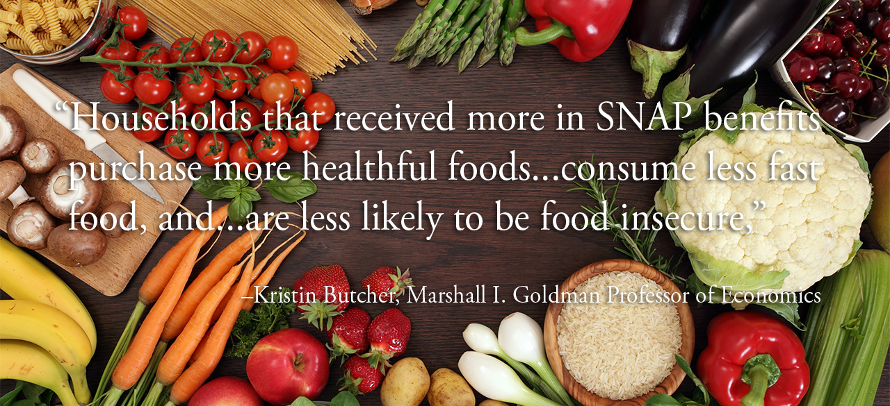Kristin Butcher, Professor of Economics, on SNAP Benefits Healthy foods circle a space on a table, a quote from Prof. Kristin Butcher is overlaid