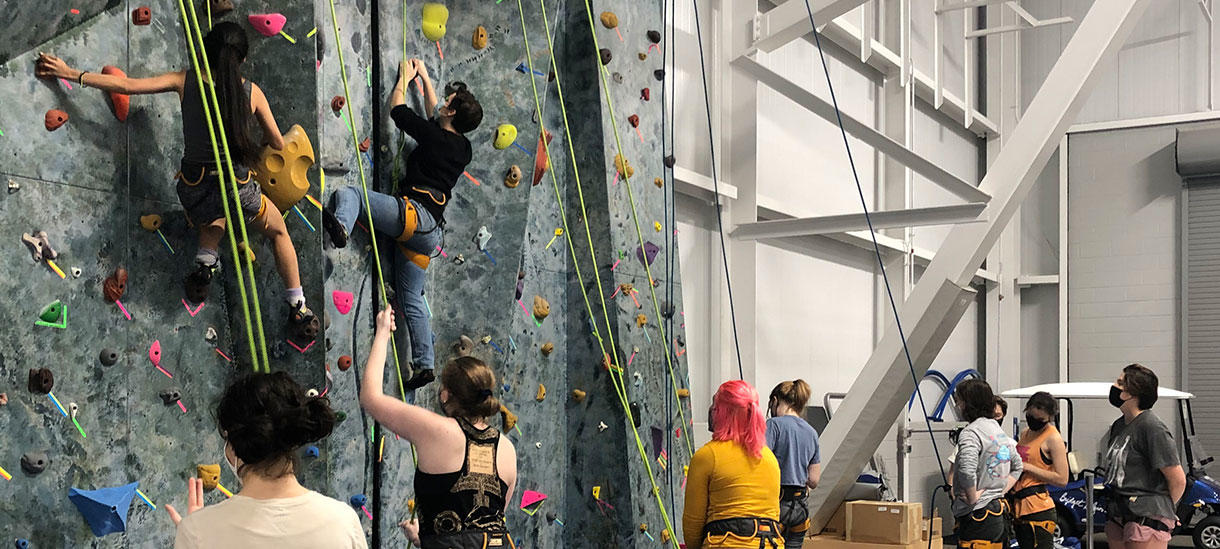climbing wall, students observing classmates climbing