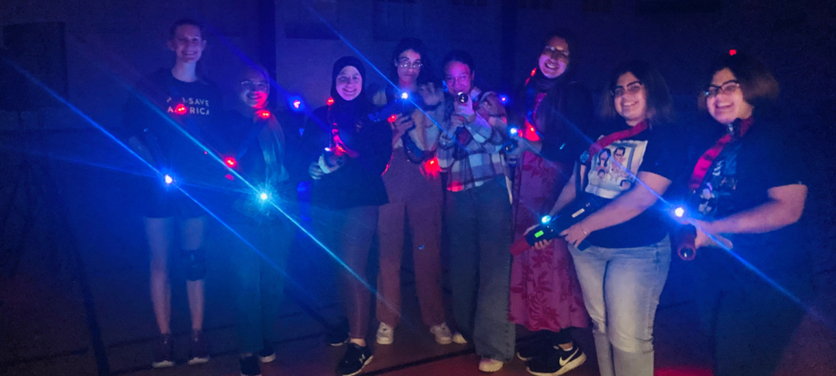 students holding glowing laser tag packs
