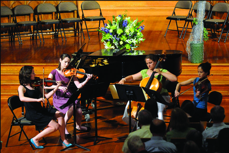 A chamber music society group performs on stage