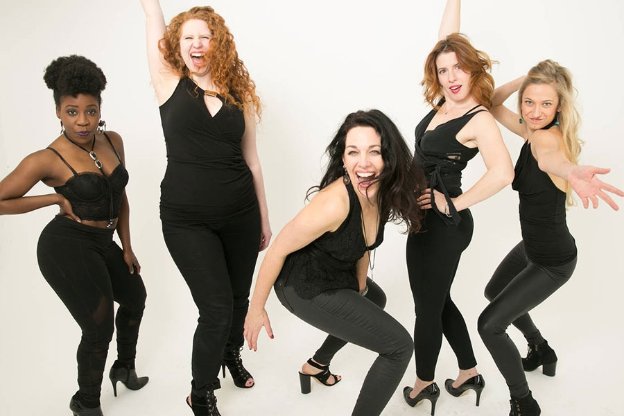 image of five women wearing black and making comedic gestures