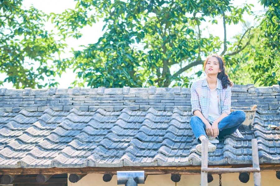 girl sitting on a roof in Little Forest