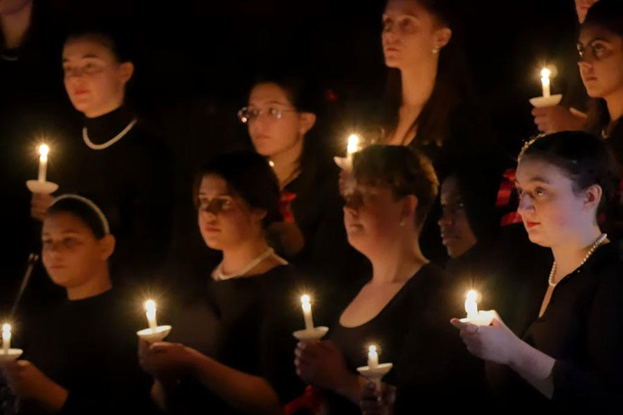 people singing while holding candles