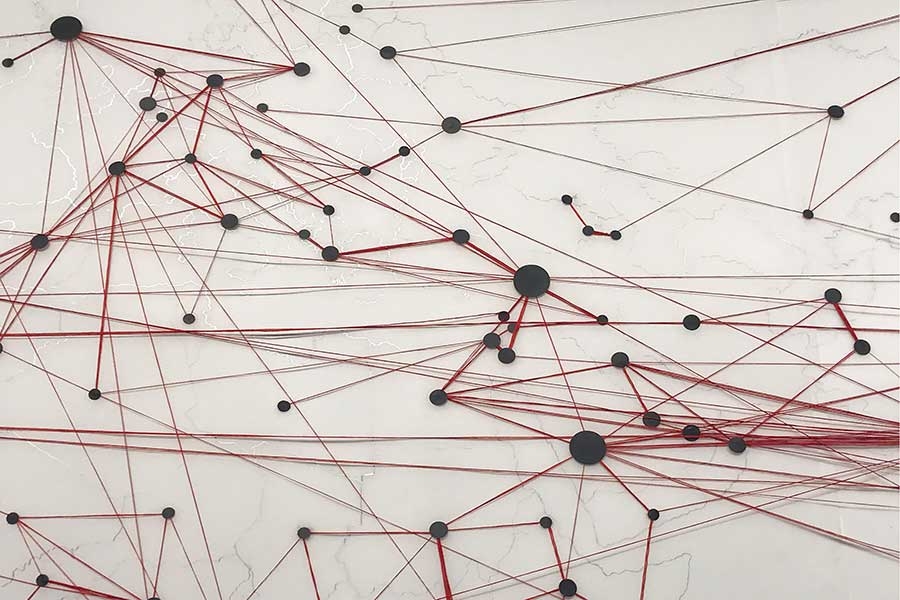 abstract art piece of red string strung between black dots.