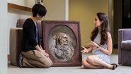 College Archivist Jane Callahan and Student Kathryn Cooperman discuss a bronze relief that was recently located in the College Archives after a months-long search.