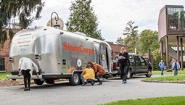 The StoryCorps MobileBooth Visits Wellesley Campus A silver airstream trailer, the StoryCorps MobileBooth, parked near the Wellelsey student center