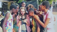 students gather round Hanna Tenerowicz showing images on her camera