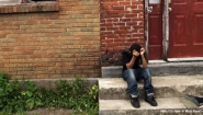 10-year old kid alone on a city stoop, head in hands