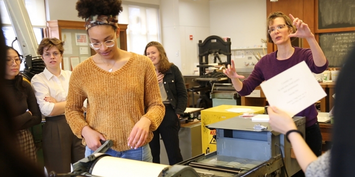 On National Haiku Poetry Day, Wellesley Shines a Spotlight on the Book Arts Lab A student uses a printing press while her class and professor look on.