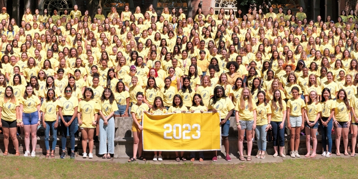 In the College’s Catalogs, a Tale of Wellesley Through Time The class of 2023's class photo. They wear yellow shirts and hold a yellow banner.