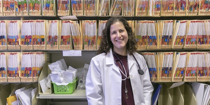 Meet Jennifer Schwartz, Wellesley’s New Medical Director of Health Services and Sports Medicine A woman in a white lab coat stands in front of rows of files.