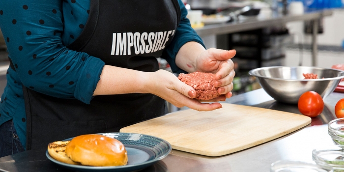 From the Impossible Whopper to Tofurkey: What’s the Environmental Impact of Plant-Based Meat? A woman creates a ball of "impossible burger."