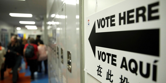 2018 Saw Big Surge in Wellesley Student Voting A sign on a wall by lockers reads Vote Here in English and Spanish
