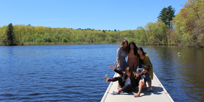 And That’s a Wrap! Wellesley Closes Out the 2018–19 Academic Year Students stand on a dock by Lake Waban preparing to take a photo.