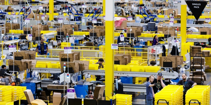 How the Rise in Online Shopping Affects the Planet workers in an Amazon shipping warehouse