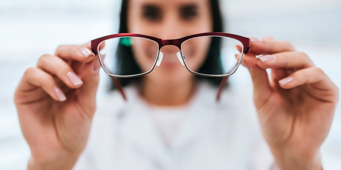 Do Glasses-Wearing Candidates Have an Edge? Wellesley Professor Weighs In A woman holds eye glasses.