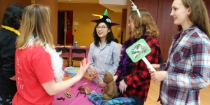 Balance Health Educators Host Sleep Health Panel, Bringing Focus to the Importance of Sleep in Overall Health and Wellness Students stand around a table with dress up props on it.