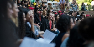Students Encouraged to Bridge Divides at Convocation A student laughs amid a crowd of students in the theater