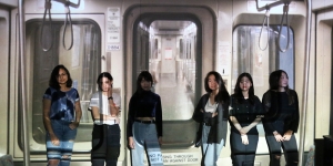 Students Construct a Multimedia Art Installation for the Community Day of Poetry Six students stand in front of an art installation that depicts the inside of the MBTA's Red Line.