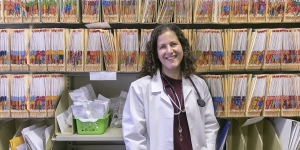 Meet Jennifer Schwartz, Wellesley’s New Medical Director of Health Services and Sports Medicine A woman in a white lab coat stands in front of rows of files.