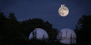 Wellesley Physicist Researches the Moon Using Instrument Left by Apollo 11 A large full moon with a tiny astronaut holding an American flag floats above the observatory.