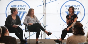 First Wellesley Alumna to Compete in Olympics for the United States Returns to Campus Clare Egan sits with two students talk to a crowd of people.