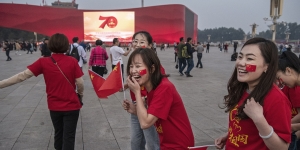 The People’s Republic of China at 70: How Chinese Literature and Cinema Illuminate the Cultural Revolution and Its Aftermath Chinese tourists wear 70th anniversary t-shirts as they stand near a large screen set up for the 70th National Day celebrations