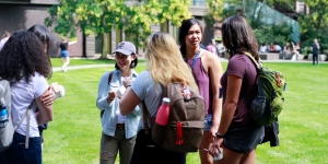 As Orientation Begins, Wellesley’s Trained 2018 Student Leaders Get to Work A group of student leaders stand outside at an ice cream social, talking.