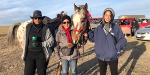 On Horseback with the Lakota Sioux, Wellesley Professor Honors Those Killed in the Wounded Knee Massacre A professor and two alumnae stand with a horse