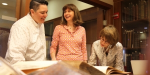 Wellesley Alumnae and Staff Speak to Students about Careers in Libraries and Archives Three members of the archives and special collections staff look at a book.
