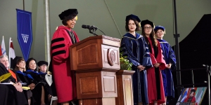 Wellesley Honors Three Professors for Excellence in Teaching Three professors stand on a stage while the president presents them with an award.