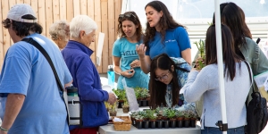 Free Plants from the Botanic Gardens Brighten First-Year Students’ Dorm Rooms Students and community members gather around small potted plants.