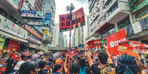 Wellesley Expert on Contemporary China Discusses Hong Kong Demonstrations Protestors stand in a street in Hong Kong with signs.