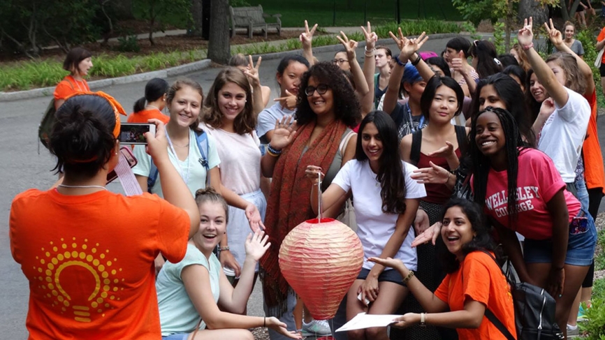 A group of students pose with a prize found during their orientation. A student takes their photo