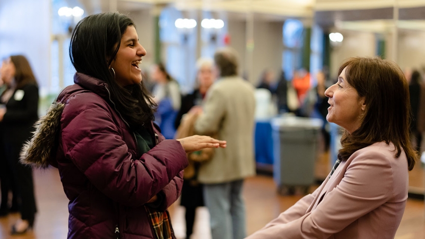 Jane Mayer speaks to a student at a reception.