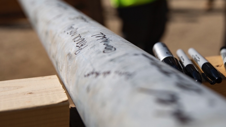 The beam with signatures in black permanent marker.