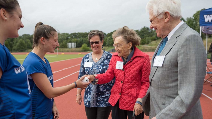 The donors of the turf field talk with students on the new track.