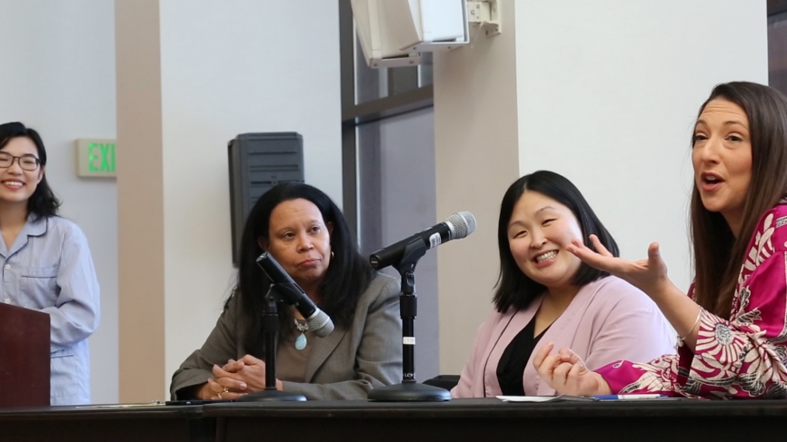 The panel speaks to an audience of students and staff.