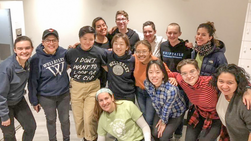 students stand in a group photo smiling at the camera