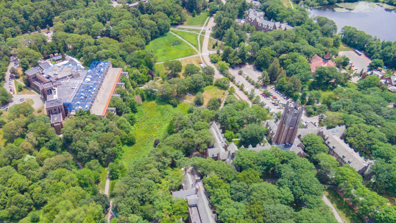 An aerial view of Wellesley's campus featuring lake waban and green hall.