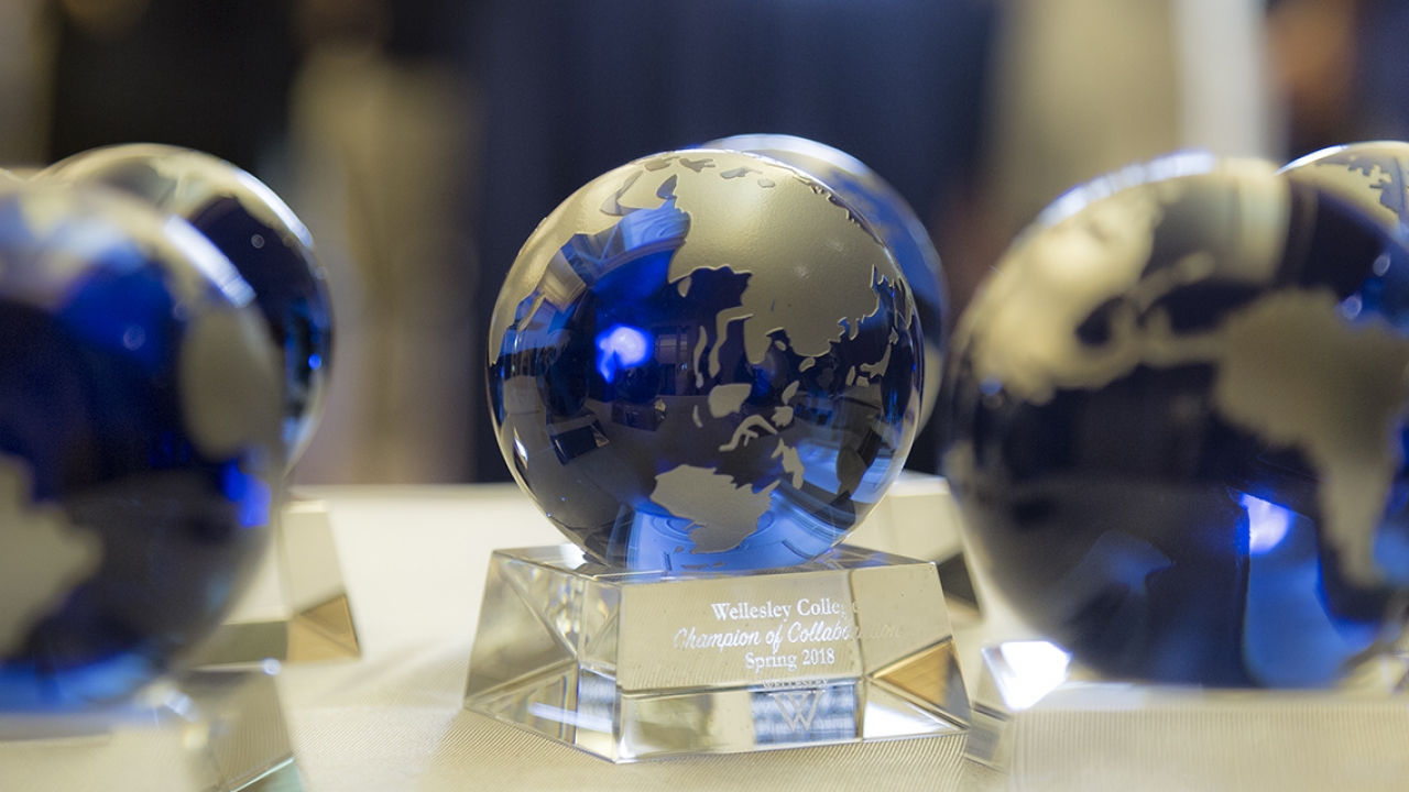 Faculty and staff recognition awards shaped as a globe sit on a table.