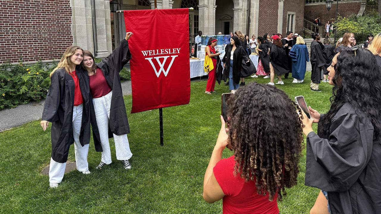 Seniors gather around the 2024 class banner for photos before convocation.