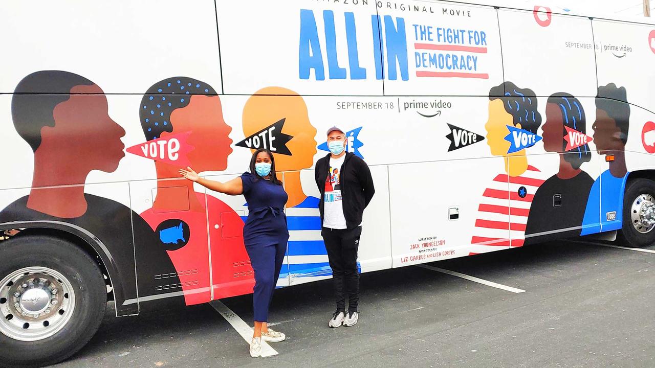 joy stiles and another person standing in front of a bus