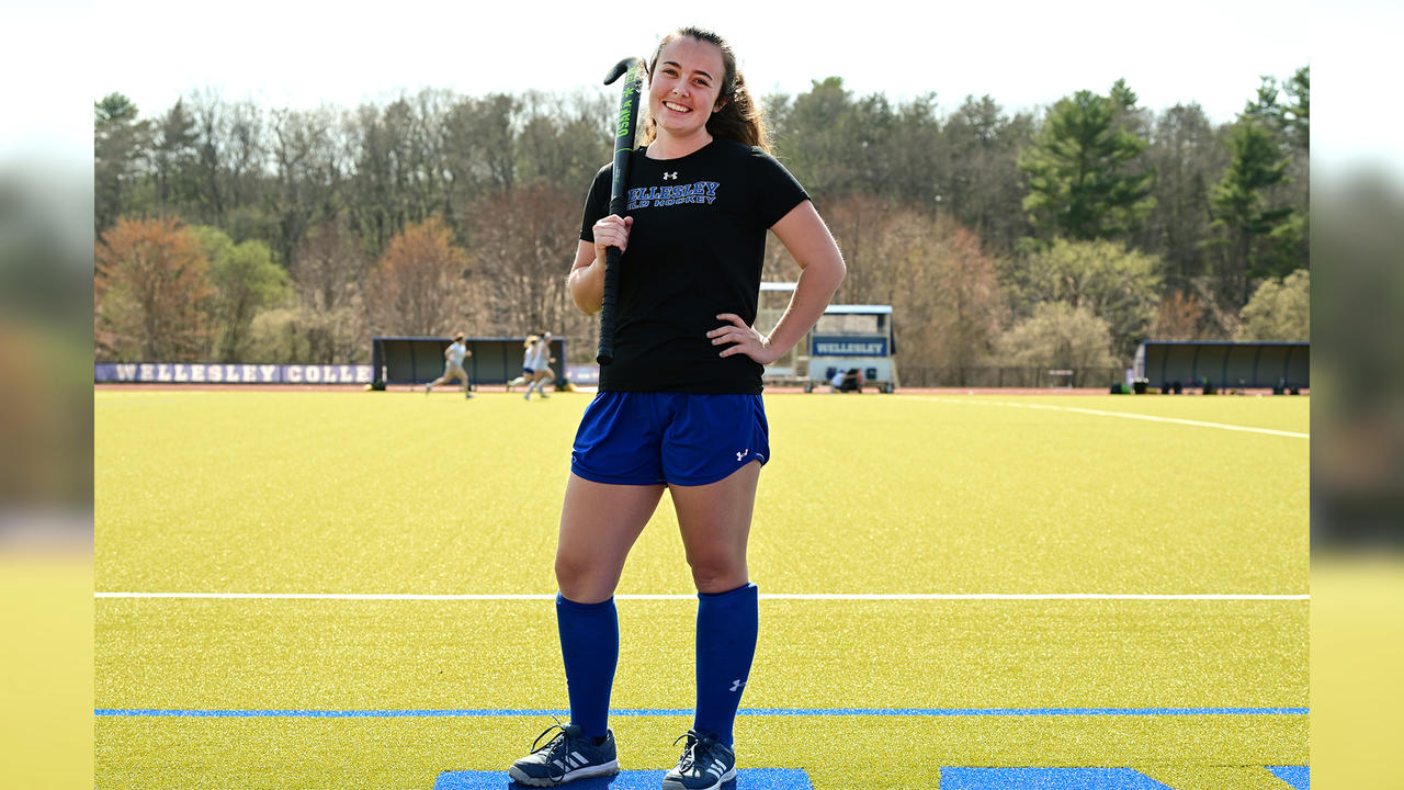 Lindsay Strong ’23 stands on field hockey field with stick over her shoulder