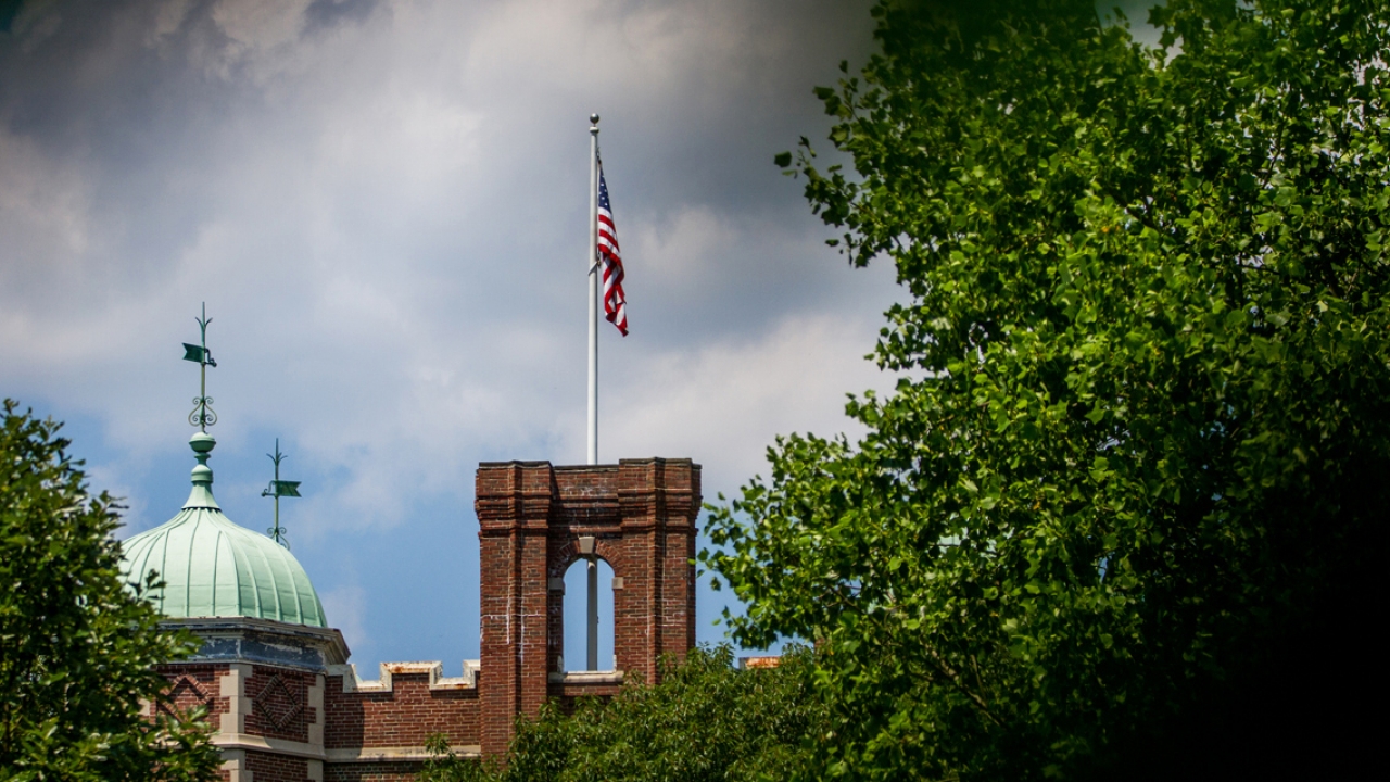A photo of a flag on top of a residence hall.